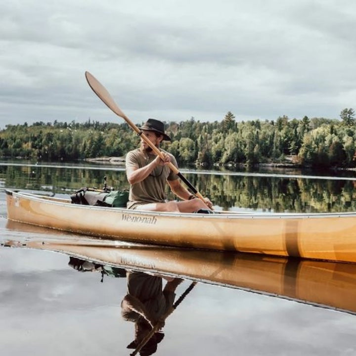 man paddling a canoe solo