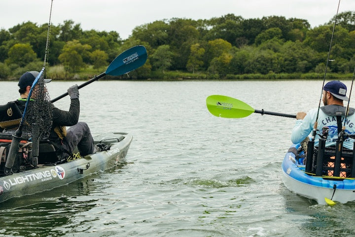 two men paddling fishing kayaks