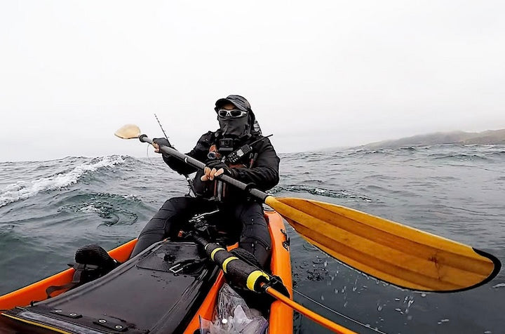 a man kayaks on the ocean with his Bending Branches Angler Navigator paddle